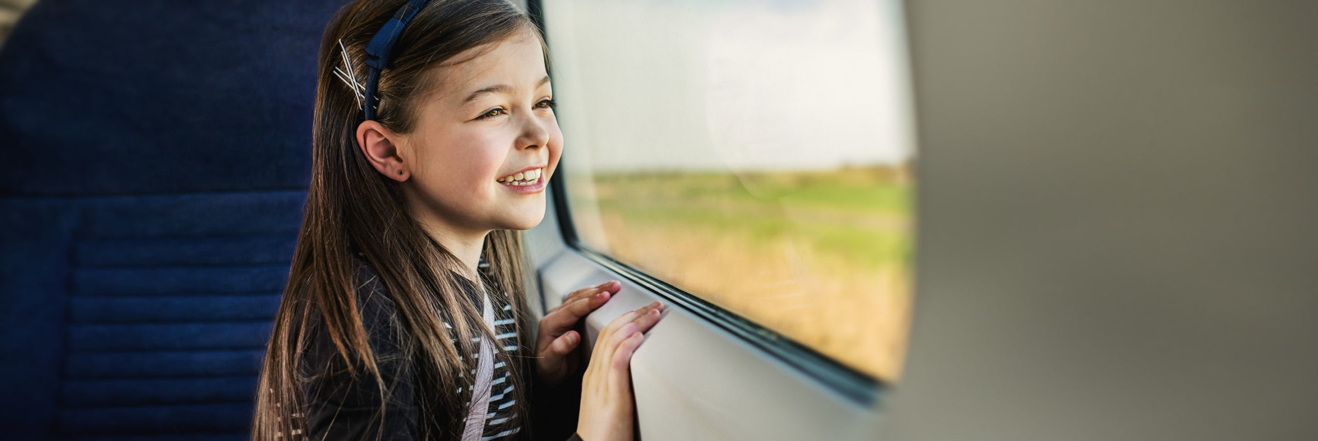 A smiling young passenger on a train